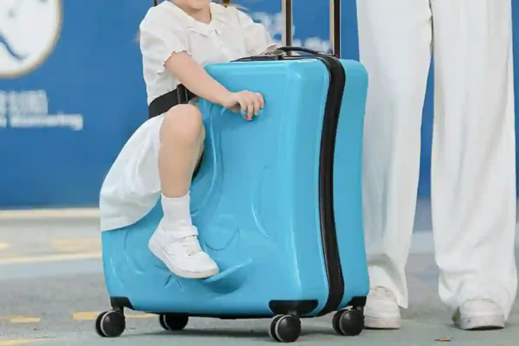 Child sitting on a Duffel profile ride-on suitcase with wheels at airport
