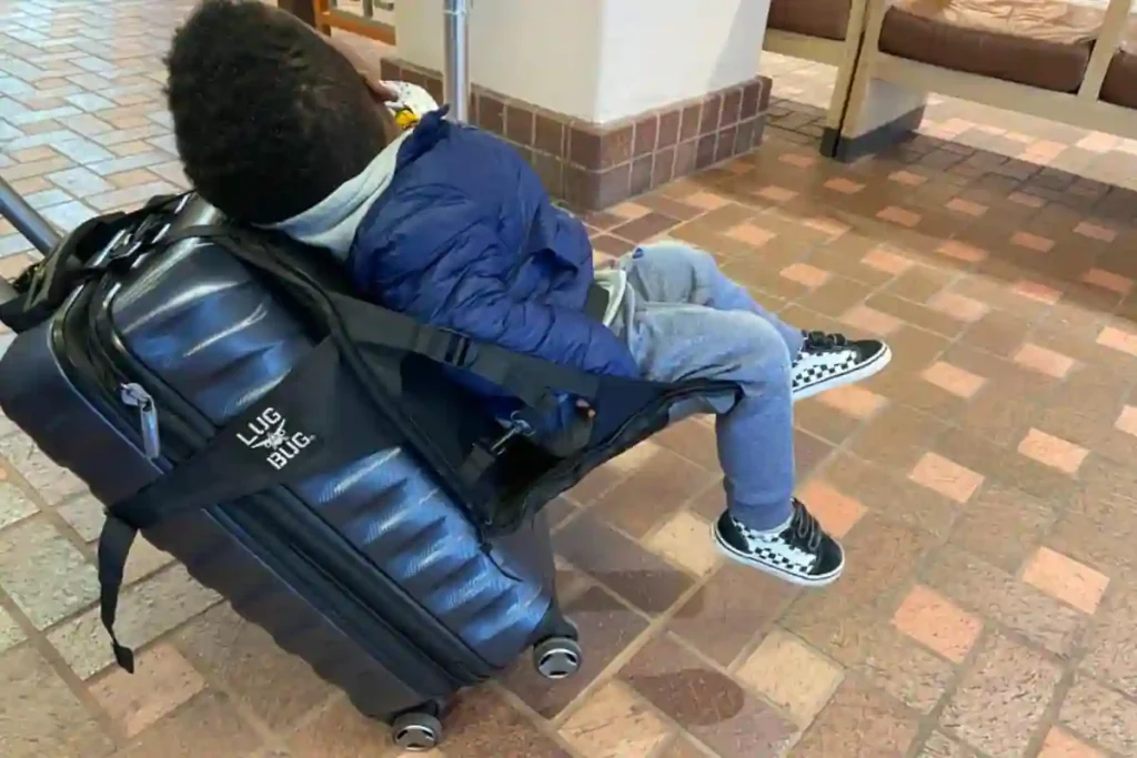 Parent pulling suitcase with built-in toddler seat at airport