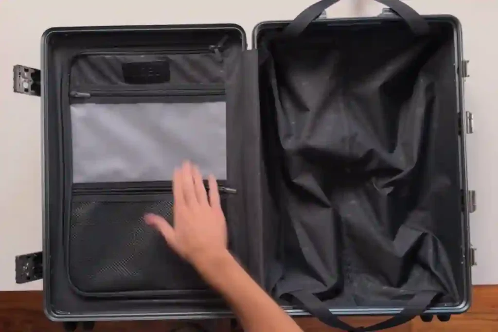 NOBL suitcase showing soft-close handles, spinner wheels, and TSA-locked front laptop compartment.