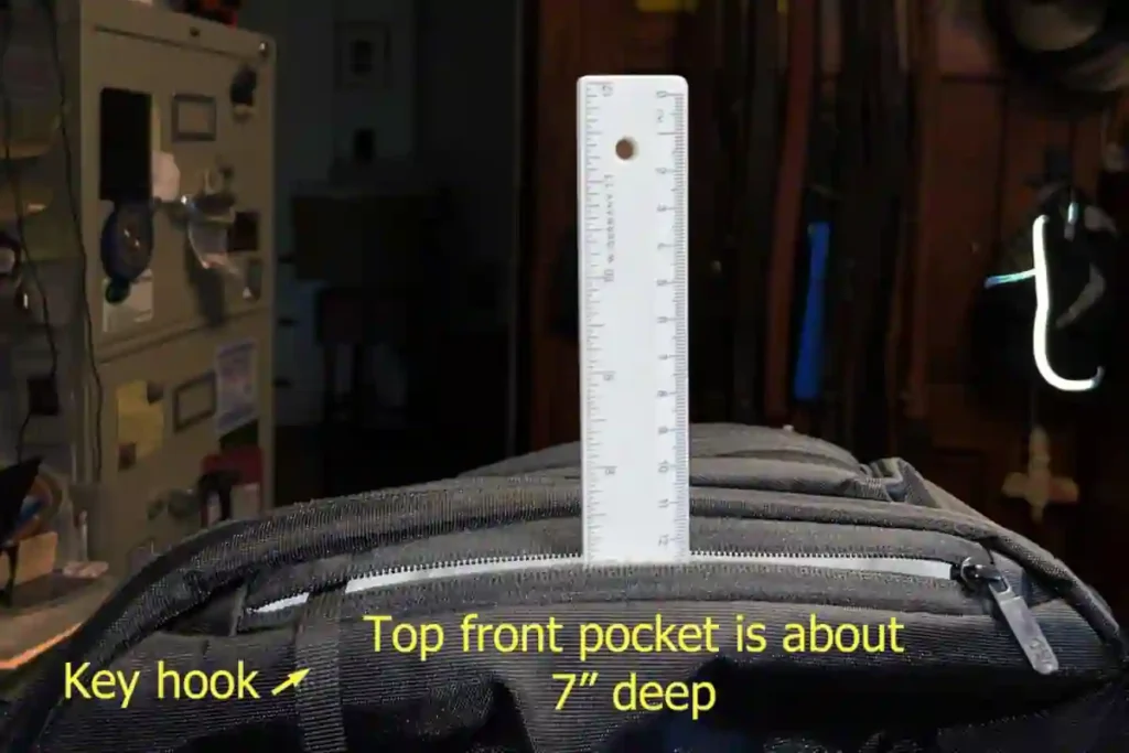 Top front quick-access pocket on the Tortuga Daily Carry Pro showing a key hook and approximately 7-inch pocket depth measured with a ruler