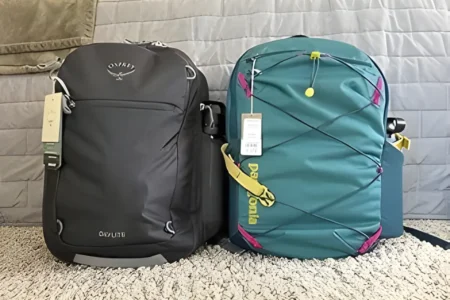 Front view of the Osprey Daylite Expandable 26+6 travel backpack in Black against a travel background.